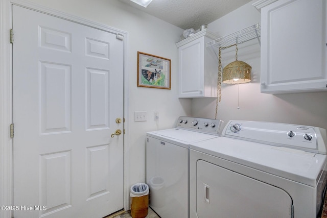 laundry area featuring cabinet space, a textured ceiling, and washing machine and dryer