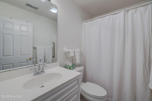 bathroom featuring vanity, toilet, and visible vents