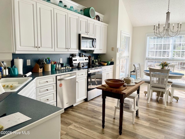 kitchen featuring dark countertops, white cabinets, and stainless steel appliances