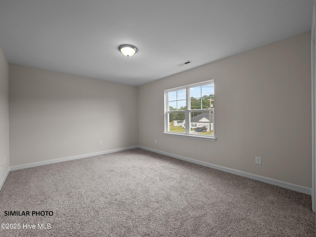 carpeted spare room with visible vents and baseboards