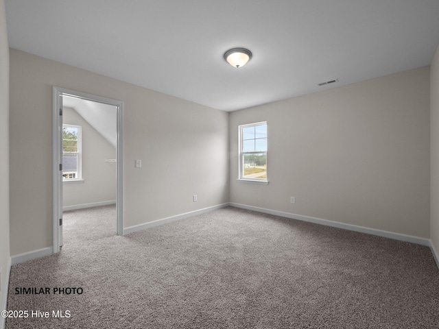 carpeted empty room featuring baseboards and visible vents