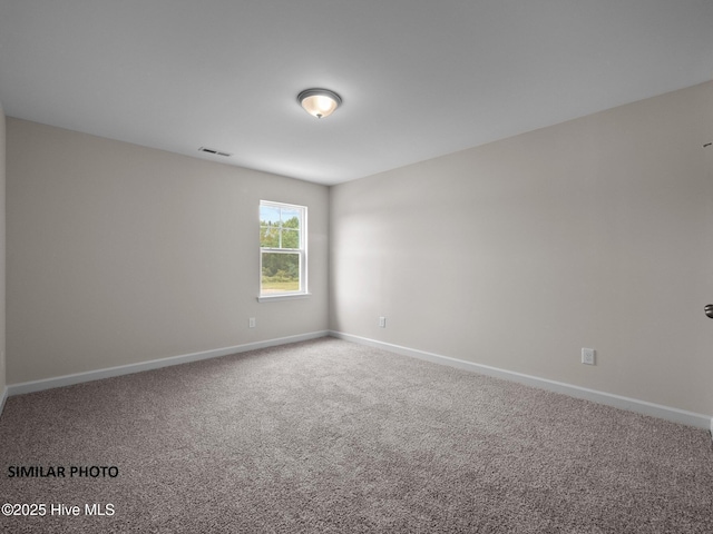 carpeted empty room featuring visible vents and baseboards