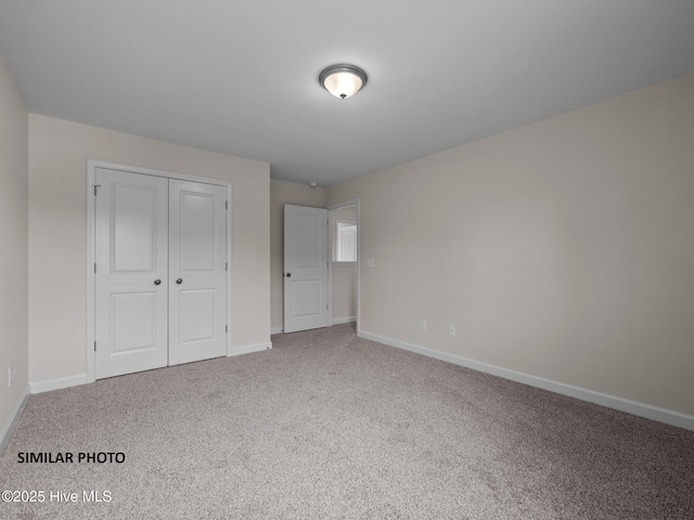 unfurnished bedroom featuring a closet, carpet flooring, and baseboards