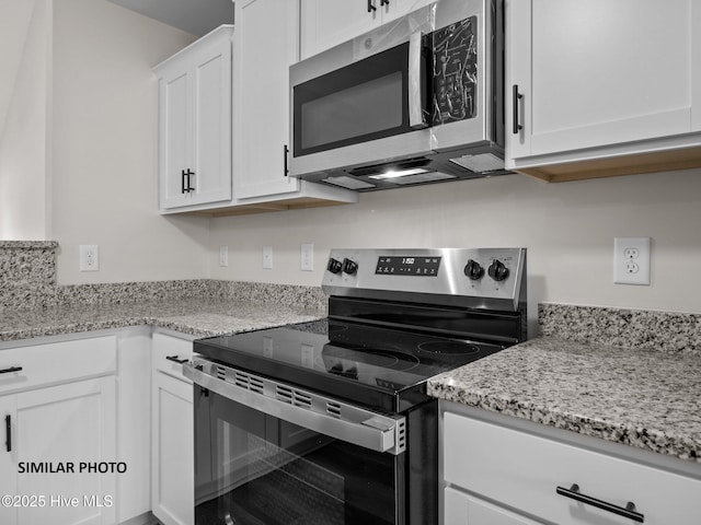 kitchen featuring white cabinets, light stone countertops, and stainless steel appliances