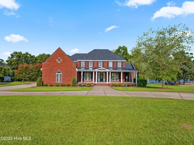 view of front facade featuring a standing seam roof, a porch, metal roof, and a front yard