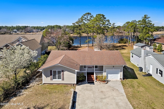 view of front of property with a porch, concrete driveway, a front lawn, a garage, and a water view