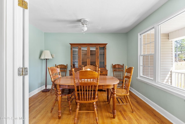 dining space with a ceiling fan, light wood-style floors, and baseboards