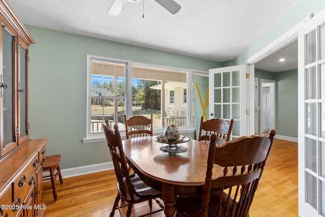 dining space featuring light wood finished floors, french doors, and baseboards