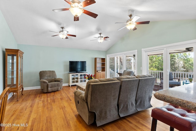 living area with high vaulted ceiling, baseboards, light wood-style floors, and a ceiling fan