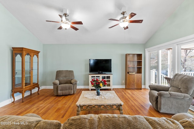 living area with baseboards, high vaulted ceiling, wood finished floors, and a ceiling fan