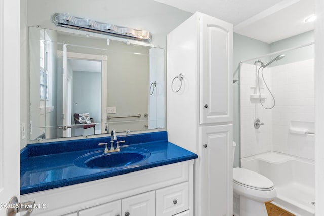 bathroom featuring toilet, vanity, and walk in shower