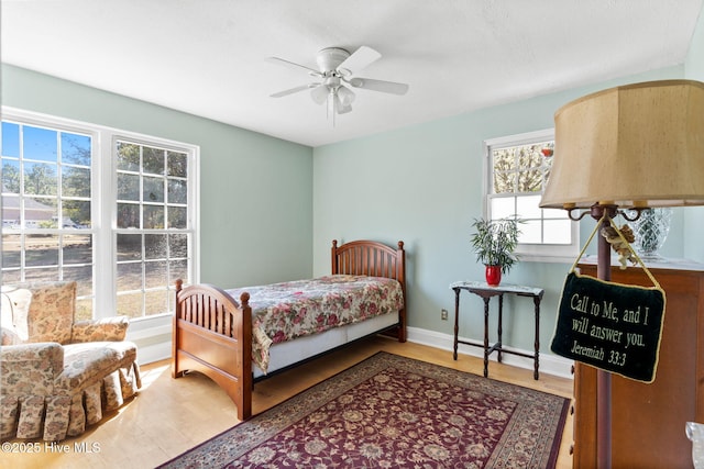 bedroom with a ceiling fan, baseboards, and wood finished floors