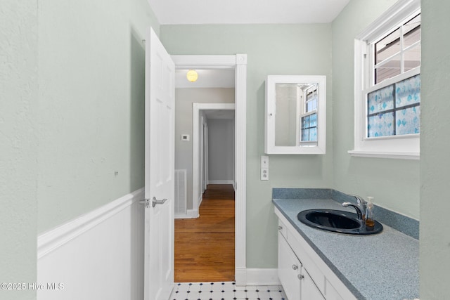 bathroom with visible vents, a wainscoted wall, and vanity