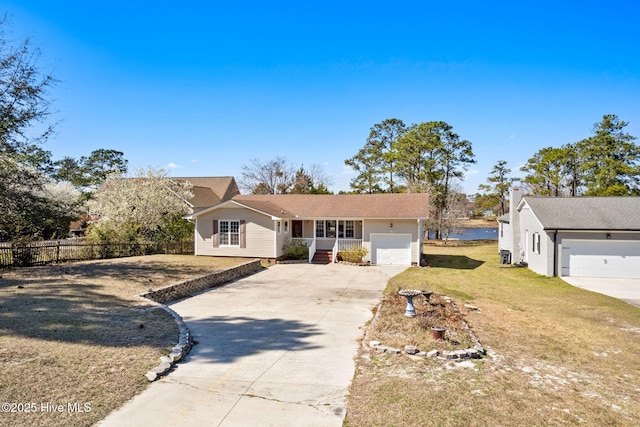 view of front of property with a front yard, an attached garage, fence, and driveway