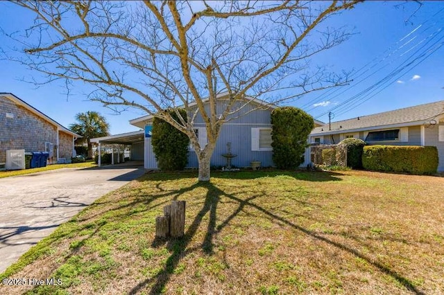 view of front of property featuring a front yard, an attached carport, and driveway