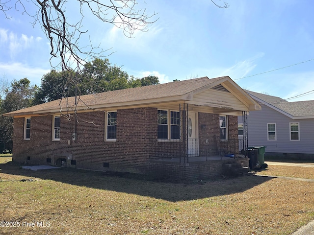 view of front facade featuring crawl space, covered porch, a front yard, and brick siding