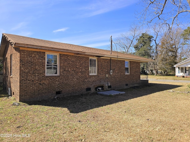 rear view of house featuring crawl space, brick siding, and a lawn