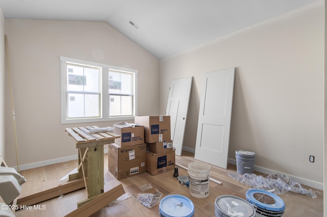 interior space featuring vaulted ceiling, light wood-type flooring, and baseboards