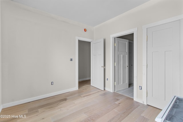unfurnished bedroom with light wood finished floors and baseboards