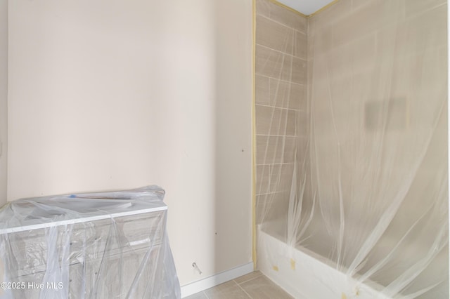 full bath featuring a shower, a tub to relax in, and baseboards