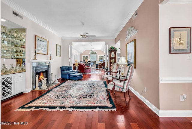 living area featuring visible vents, ornamental molding, and a fireplace