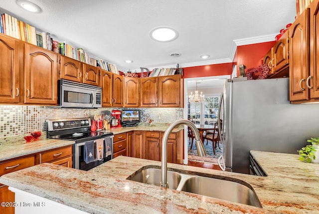 kitchen featuring a sink, light stone counters, tasteful backsplash, appliances with stainless steel finishes, and brown cabinetry