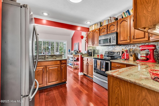 kitchen featuring brown cabinets, appliances with stainless steel finishes, and a sink