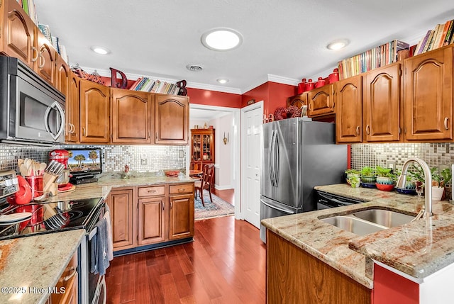 kitchen with dark wood-style floors, visible vents, light stone countertops, a sink, and stainless steel appliances