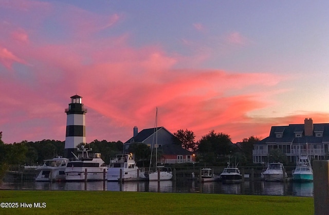 view of property's community featuring a yard, a dock, and a water view