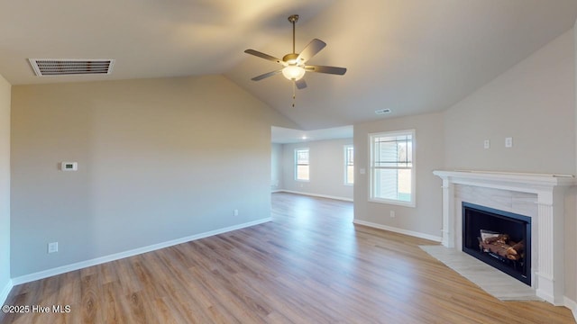 unfurnished living room with a ceiling fan, light wood-style floors, visible vents, and a high end fireplace