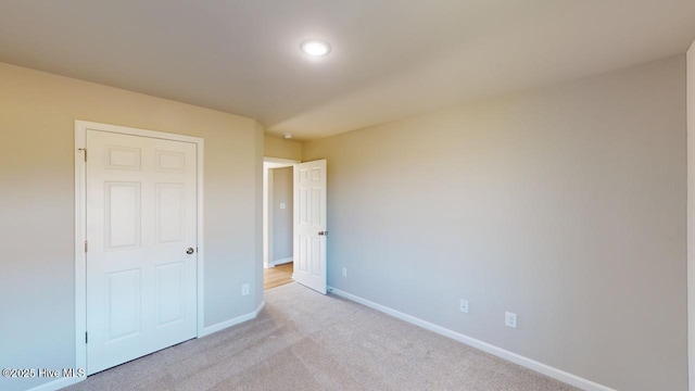 unfurnished bedroom with baseboards and light colored carpet