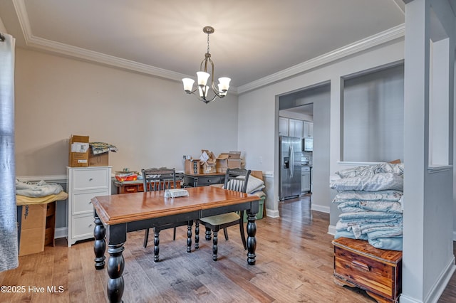 home office with an inviting chandelier, light wood-style flooring, and ornamental molding