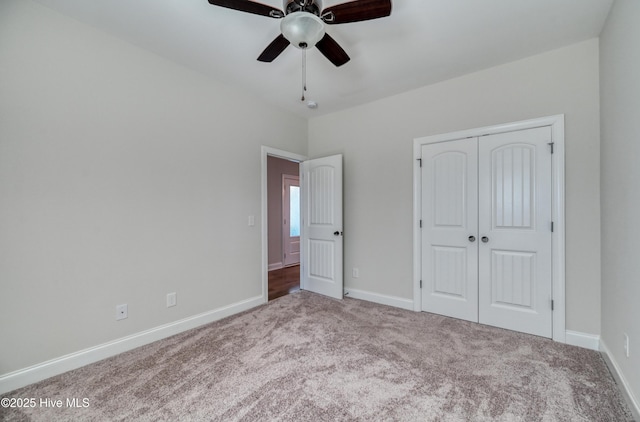 unfurnished bedroom with a closet, baseboards, a ceiling fan, and carpet flooring