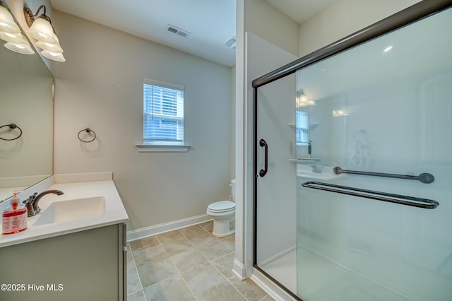 bathroom featuring vanity, a shower stall, toilet, and baseboards