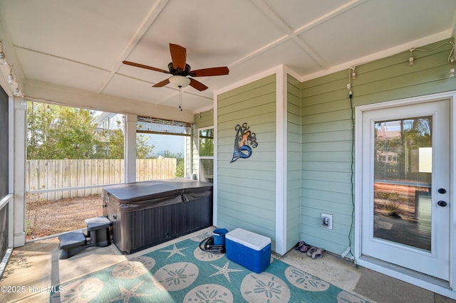 view of patio featuring a ceiling fan, fence, and a hot tub