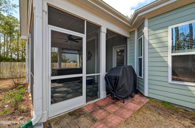 view of patio / terrace featuring fence, a sunroom, and grilling area