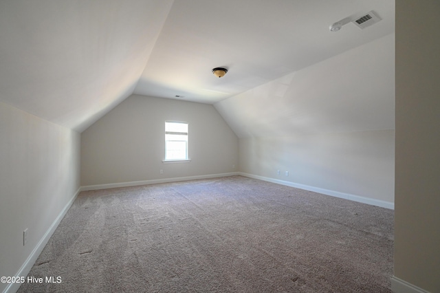 additional living space featuring visible vents, baseboards, lofted ceiling, and carpet floors