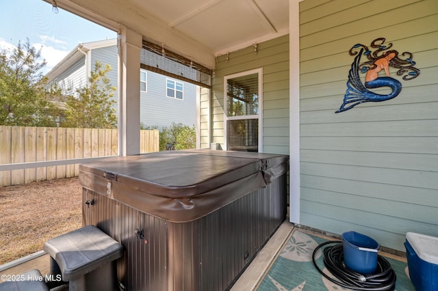 view of patio featuring fence and a hot tub