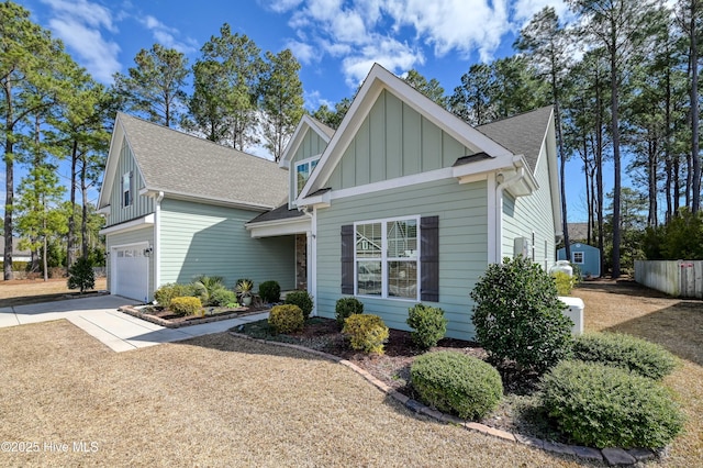 view of front facade with board and batten siding, driveway, and a shingled roof