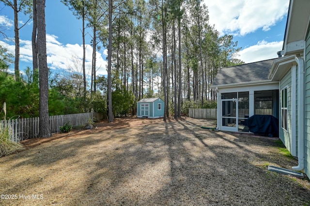 view of yard with an outbuilding, a storage unit, fence private yard, and a sunroom