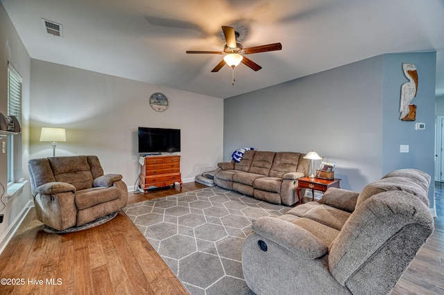 living area with visible vents, baseboards, ceiling fan, and wood finished floors