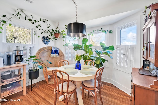 dining area featuring light wood-style flooring and baseboards