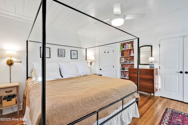 bedroom with ornamental molding, wooden ceiling, a ceiling fan, and wood finished floors