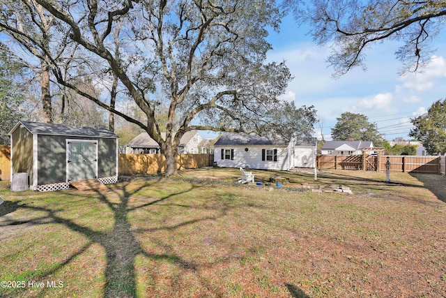 view of yard with an outbuilding, a storage unit, and a fenced backyard