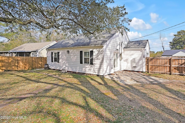 back of house with driveway, a yard, and fence