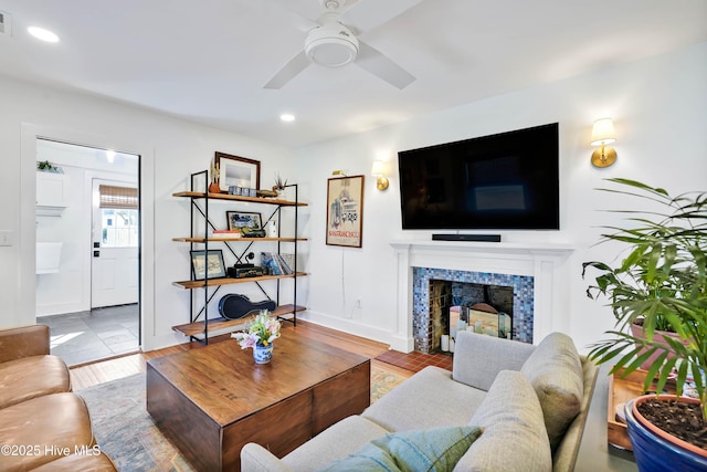 living area featuring recessed lighting, a fireplace, a ceiling fan, and wood finished floors