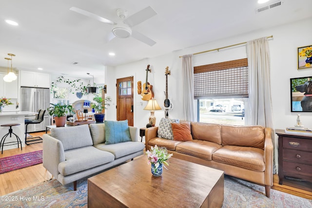 living area featuring recessed lighting, a healthy amount of sunlight, visible vents, and light wood-type flooring