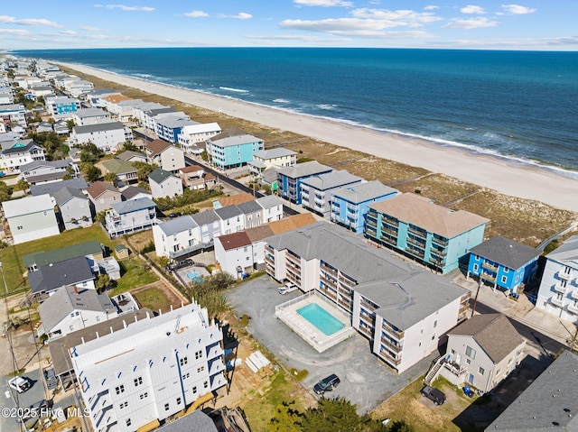 birds eye view of property featuring a beach view and a water view