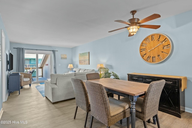 dining space with light wood-type flooring and baseboards