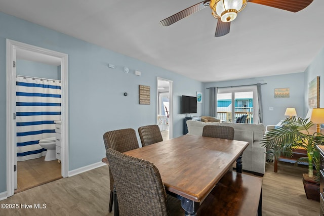 dining area with baseboards, wood finished floors, and a ceiling fan